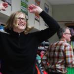 Karen Lloyd, director of the Veterans History Project at the Library of Congress in Washington, D.C., dances the hokey pokey along with West Homer Elementary Principal Eric Waltenbaugh (background) during a special lesson taught by retired McNeil Canyon teacher Bill Noomah on Thursday, Oct. 19, 2017 at the elementary school in Homer, Alaska. Noomah, whose lesson was created to teach kids about Veterans Day and about using primary sources in research, had the students (and adults) take breaks by getting up and dancing. Lloyd was visiting Alaska from D.C. and came to Homer when she heard Noomah would be presenting his lesson, which is based on a collection from the Veterans History Project. (Photo by Megan Pacer/Homer News)