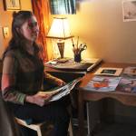 Oceana Wills, a local artist and commercial fisherman, goes through some of her paintings Friday, Nov. 10, 2017 at the cabin where she&rsquo;s living for the winter in Kachemak City, Alaska. (Photo by Megan Pacer/Homer News)