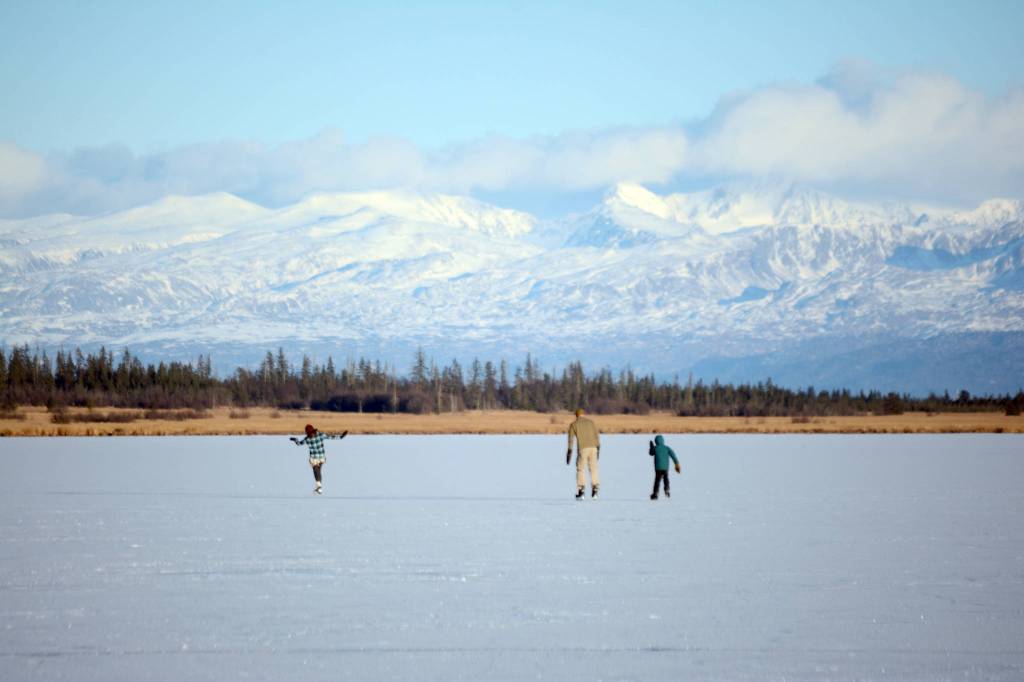 Skaters glide across Beluga Lake last Friday afternoon, Nov. 17, 2017 in Homer, Alaska. With clear and cold weather, the lake has frozen enough to support ice skating. A slight dusting of snow last Thursday didn&rsquo;t affect skating. (Photo by Michael Armstrong, Homer News)