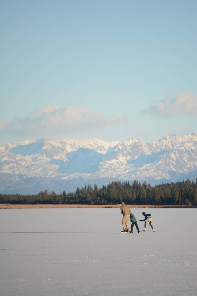 Skaters glide across Beluga Lake last Friday afternoon, Nov. 17, 2017 in Homer, Alaska. With clear and cold weather, the lake has frozen enough to support ice skating. A slight dusting of snow last Thursday didn&rsquo;t affect skating. (Photo by Michael Armstrong, Homer News)
