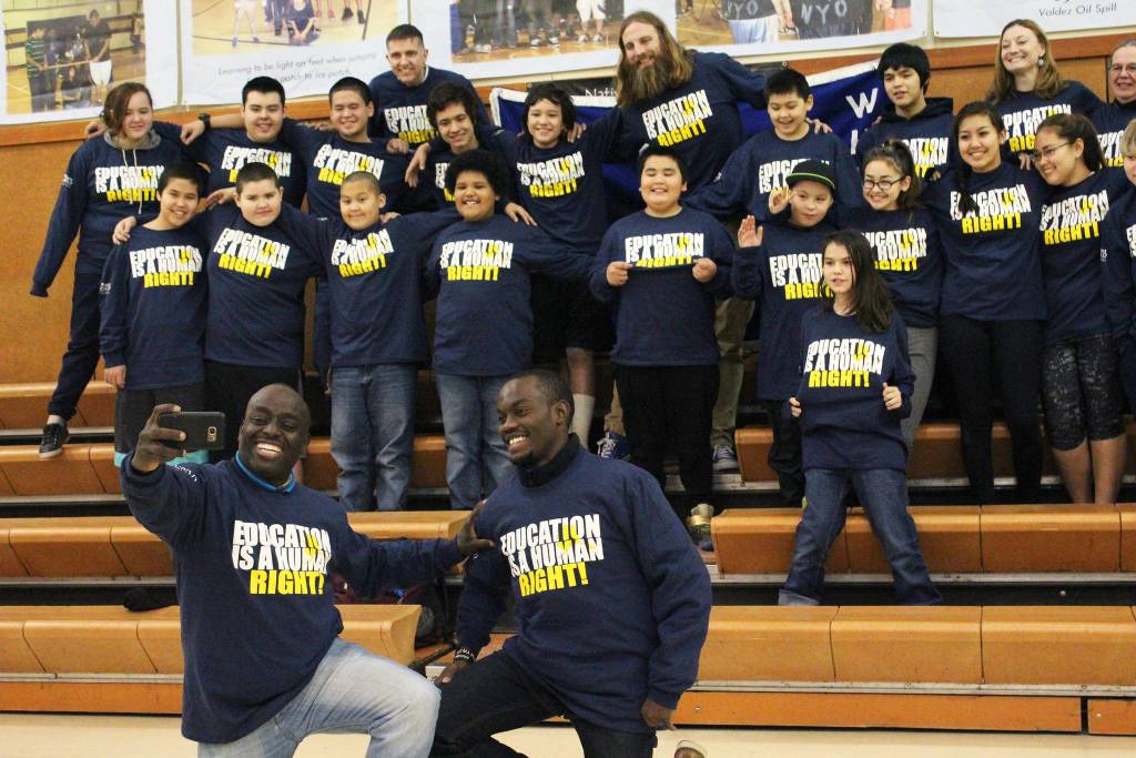Chris Mburu, left, takes a selfie with Kimani Nyambura in front of several students from Port Graham School during a presentation there Thursday, Nov. 16, 2017 in Port Graham, Alaska. The pair spoke to students from four peninsula schools about the importance of education. Mburu and Nyambura are both from the same small village in Kenya, and were able to attend school through sponsorship. Mburu is not a human rights lawyer working for the United Nations. (Photo by Megan Pacer/Homer News)