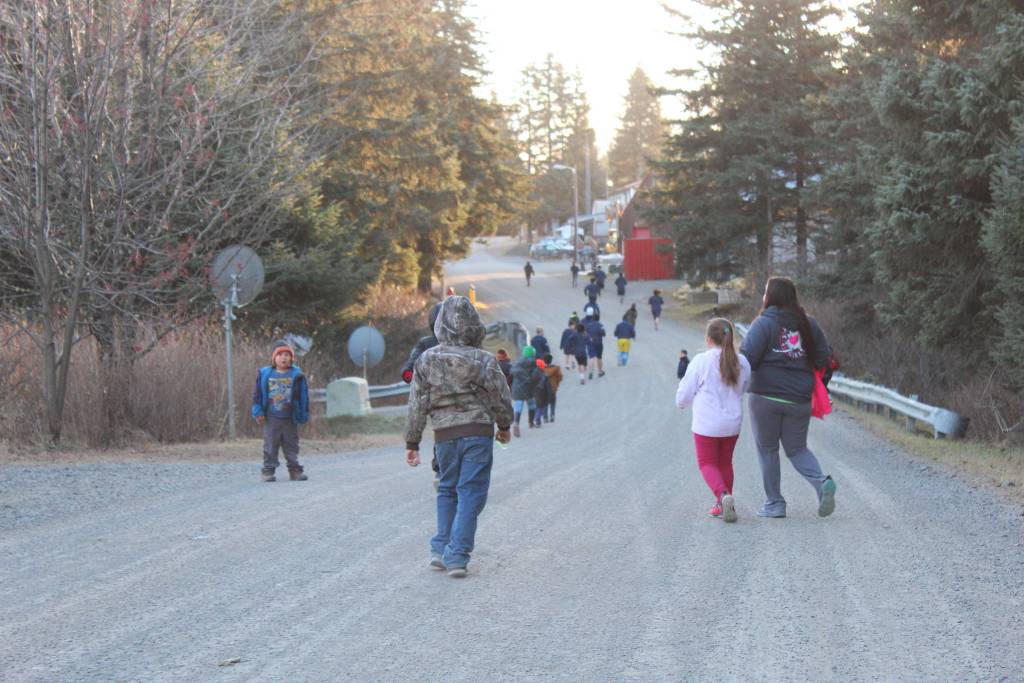 Students and faculty from Port Graham School run through the village as part of a presentation by visiting human rights lawyer Chris Mburu, who works for the United Nations, and Kimani Nyambura on Thursday, Nov. 16, 2017 in Port Graham, Alaska. The pair visited and spoke to several Kenai Peninsula schools on Nov. 16-17 about their journey through education from a small village in Kenya and Mburu&rsquo;s creation of a foundation to help Kenyan children go to school. (Photo by Megan Pacer/Homer News)