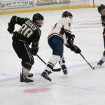 Homer&rsquo;s Dimitry Kuzmin and Colony High School&rsquo;s Foster Riekena (left) watch as Colony&rsquo;s Cooper Smith (right) hits the puck down the rink after a quick squabble for possession during their game Friday, Dec. 1, 2017 at Kevin Bell Arena in Homer, Alaska. The Mariners beat Colony 2-1 in overtime, and went on to win all three of its games over the weekend against Mat-Su Valley teams. (Photo by Megan Pacer/Homer News)