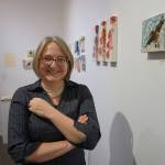 Sharlene Cline greets visitors at her First Friday opening on Friday, Dec. 1, 2017, at her show of collages using Chinese brush painting and other media at Ptarmingan Arts in Homer, Alaska. (Photo by Michael Armstrong, Homer News)