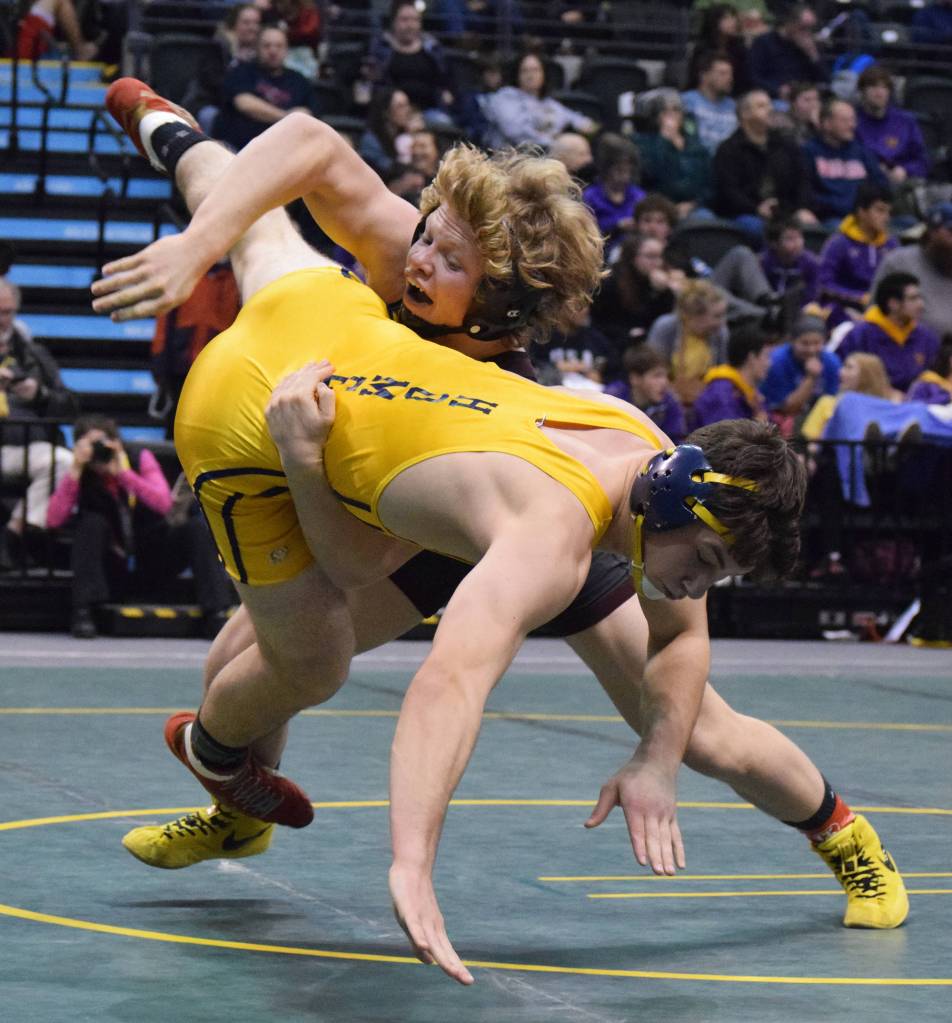 Grace Christian&rsquo;s Evan Bockman flips Homer&rsquo;s Tristen Cook on his side in the 182-pound final Saturday night at the Division II state wrestling championships at the Alaska Airlines Center in Anchorage. (Photo by Joey Klecka/Peninsula Clarion)