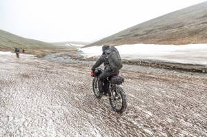 The group heads rides along snow in a creek valley. (Photo courtesy Bjorn Olson)