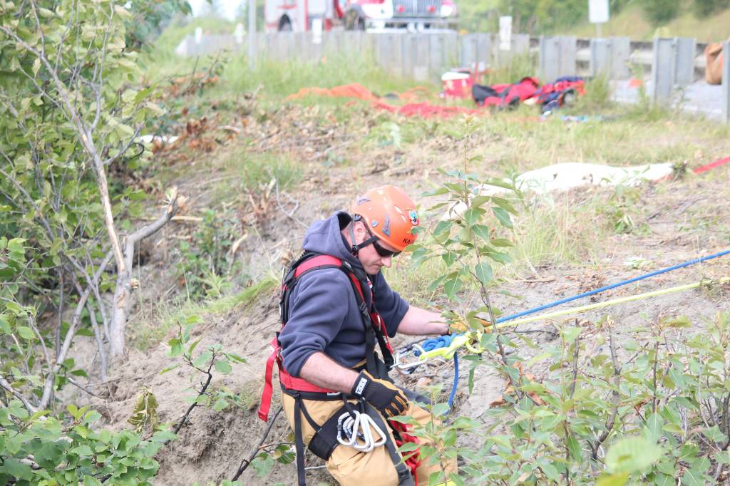 A member of Kachemak Emergency Services makes his way down the slope near Baycrest Overlook on Monday, July 24, 2017 in Homer, Alaska. First responders found a pickup truck that had fallen over the edge after hitting a guard rail on the Sterling Highway, and searched for a possible victim until getting a report that the driver had crashed several days earlier and had walked away uninjured. (Photo by Megan Pacer/Homer News)