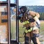 Firefighter Jesse Sherwood peers into a bus after spraying it down with foam during a simulated plane crash exercise Saturday, Aug. 19, 2017 at the Homer Airport in Homer, Alaska. He and members of several area emergency response agencies, along with airport personnel, completed the drill with the help of more than 20 volunteer &ldquo;victims.&rdquo; The drill is required every three years for the airport to stay in Federal Aviation Administration compliance. (Photo by Megan Pacer/Homer News)