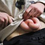 A volunteer uses the fake intestines and blood he was given to create a more realistic-looking injury prior to the start of an active shooter simulation drill Friday, Jan. 12, 2018 at the HERC building in Homer, Alaska. Police officers and first responders practiced addressing situations in tandem with each other rather than one after the other. (Photo by Megan Pacer/Homer News)