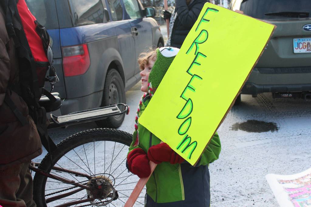 Webster Martin, 5, holds a sign reading &ldquo;Freedom&rdquo; in preparation for the Women&rsquo;s March on Homer 2018, waiting with others in the HERC Building parking lot Saturday, Jan. 20, 2018 in Homer, Alaska. Martin&rsquo;s mother, Lisa Asselin Martin, said she felt it was important for him to support his female friends, one of whom he marched with. (Photo by Megan Pacer/Homer News)