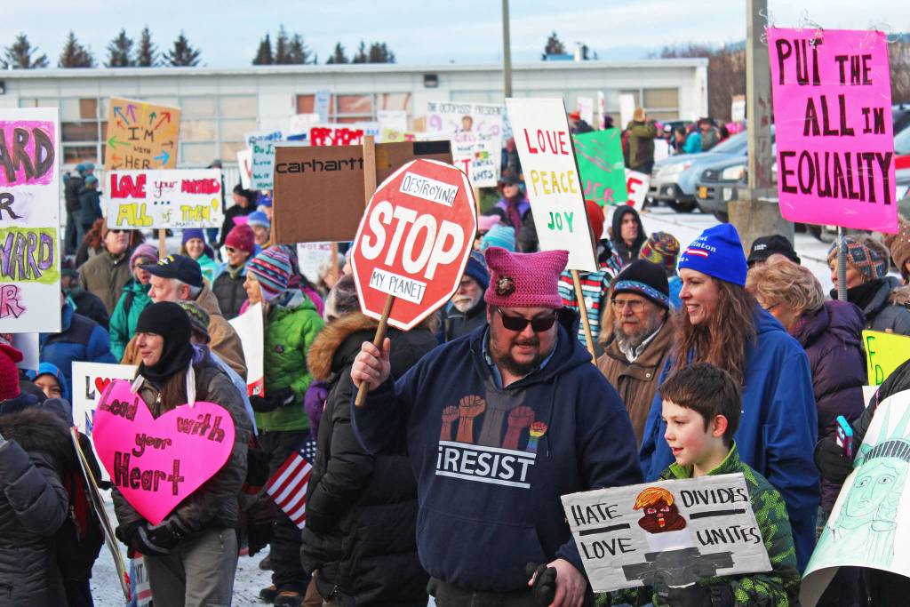 Men, women and children march out of the HERC Building parking lot at the start of the Women&rsquo;s March on Homer 2018 on Saturday, Jan. 20, 2018 in Homer, Alaska. Hundreds of people carrying messages of hope, change and progress made their way down Pioneer Avenue to WKFL Park for a photo opportunity to and special speaker. (Photo by Megan Pacer/Homer News)