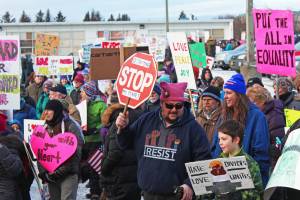Men, women and children march out of the HERC Building parking lot at the start of the Women&rsquo;s March on Homer 2018 on Saturday, Jan. 20, 2018 in Homer, Alaska. Hundreds of people carrying messages of hope, change and progress made their way down Pioneer Avenue to WKFL Park for a photo opportunity to and special speaker. (Photo by Megan Pacer/Homer News)