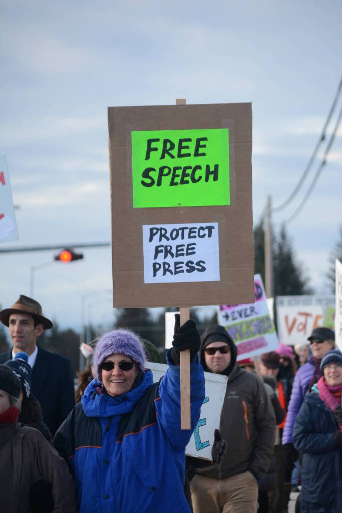 A woman carries a sign reading &ldquo;Free speech. Protect free press&rdquo; in the Homer March for Women on Saturday. About 700 people walked in the march along Pioneer Avenue on Jan. 20, 2018, in Homer, Alaska. The line of marchers extended from Main Street to Kachemak Way. (Photo by Michael Armstrong/Homer News)