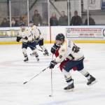 Homer&rsquo;s Ethan Pitzman passes the puck under pressure from a skater from East Anchorage High School during their game Saturday, Jan. 20, 2018 at the Kevin Bell Arena in Homer, Alaska. (Photo by Megan Pacer/Homer News)