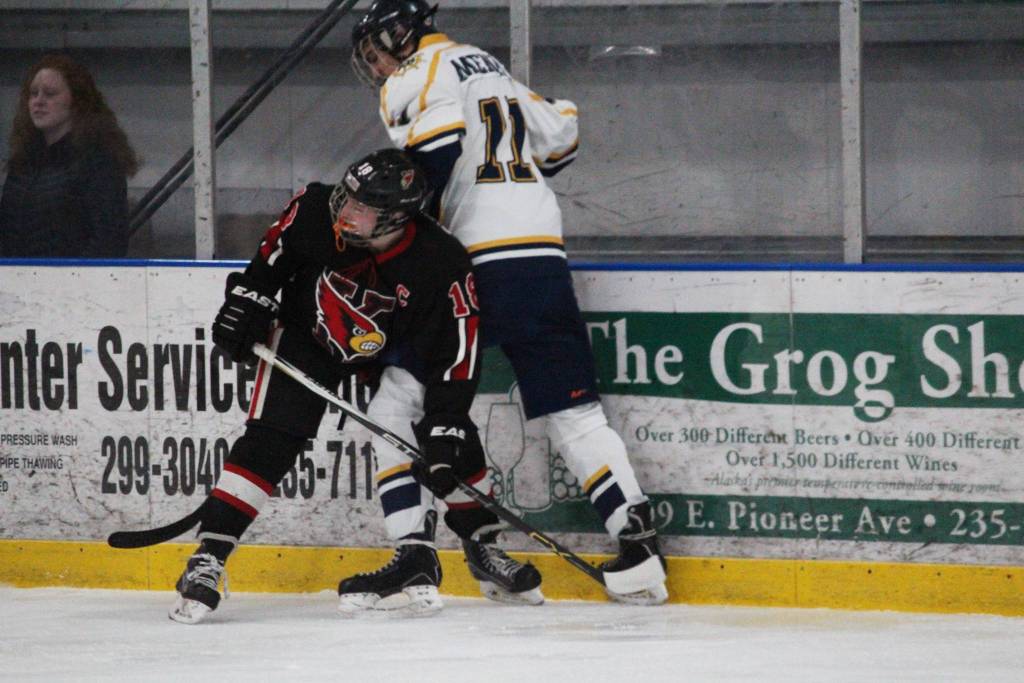 Kenai Central High School&rsquo;s Jakeb Obrien holds Homer senior Charlie Menke against the wall during their game Thursday, Jan. 25, 2018 at the Kevin Bell Arena in Homer, Alaska. The Mariners beat the Cardinals 6-5 in a tight game, their last at home. (Photo by Megan Pacer/Homer News)