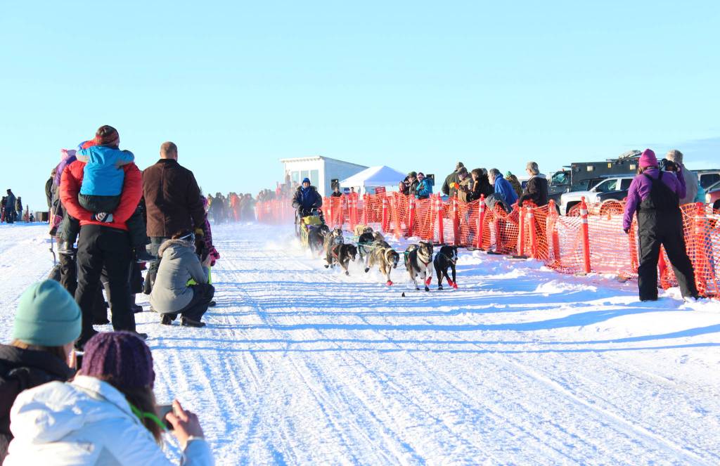 Onlookers line the race trail and snap photos as a sled dog team takes off from the starting line of the Tustumena 200 Sled Dog Race on Saturday, Jan. 27, 2018 at Freddie&rsquo;s Roadhouse in Ninilchik, Alaska. The race, which returned last year after being canceled in 2014, 2015 and 2016, is a roughly 100-mile loop that mushers will complete twice before finishing back in Ninilchik. (Photo by Megan Pacer/Homer News)