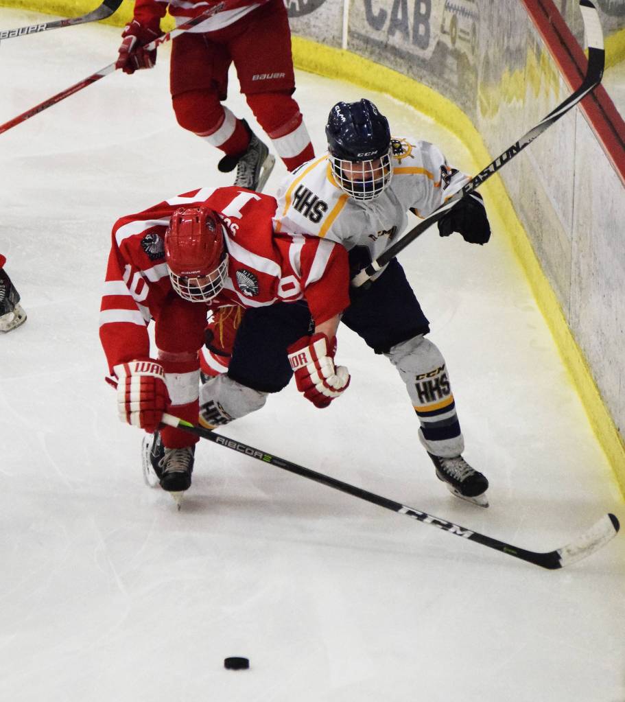 Wasilla&rsquo;s Porter Schachle (left) battles with Lee Lowe for the puck Friday in a North Star Conference tournament semifinal at the Soldotna Regional Sports Complex. (Photo by Joey Klecka/Peninsula Clarion)