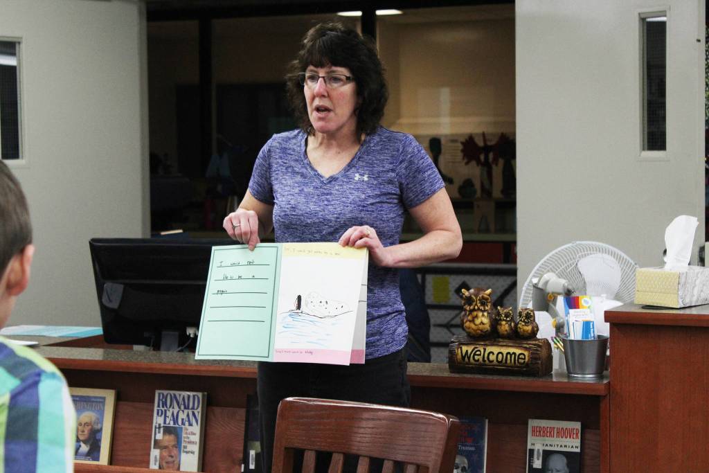 Paul Banks Elementary teacher Wendy Todd demonstrates to a group of first and seventh graders how to go about filming a performance for a combined project Friday, Feb. 2, 2018 at Homer Middle School. (Photo by Megan Pacer/Homer News)