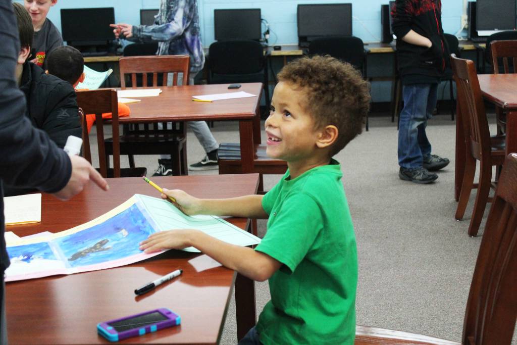 Paul Banks Elementary School first grader Elijah Williams looks up at his seventh grader partner during a mentor project Friday, Feb. 2, 2018 at Homer Middle School. (Photo by Megan Pacer/Homer News)