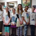 From left to right: Coach Marj Dunn, Bryce Glidden, Syde Schafli, Hadley Glidden, Juliann Techie, Bea McDonough and Coach Holly Alston sport their t-shirts for this year&rsquo;s district-wide Battle of the Books competition. The team, from West Homer Elementary School, took first place in the 5th-6th grade age division and will advance to the state competition on Wednesday, Feb. 28. (Photo submitted)