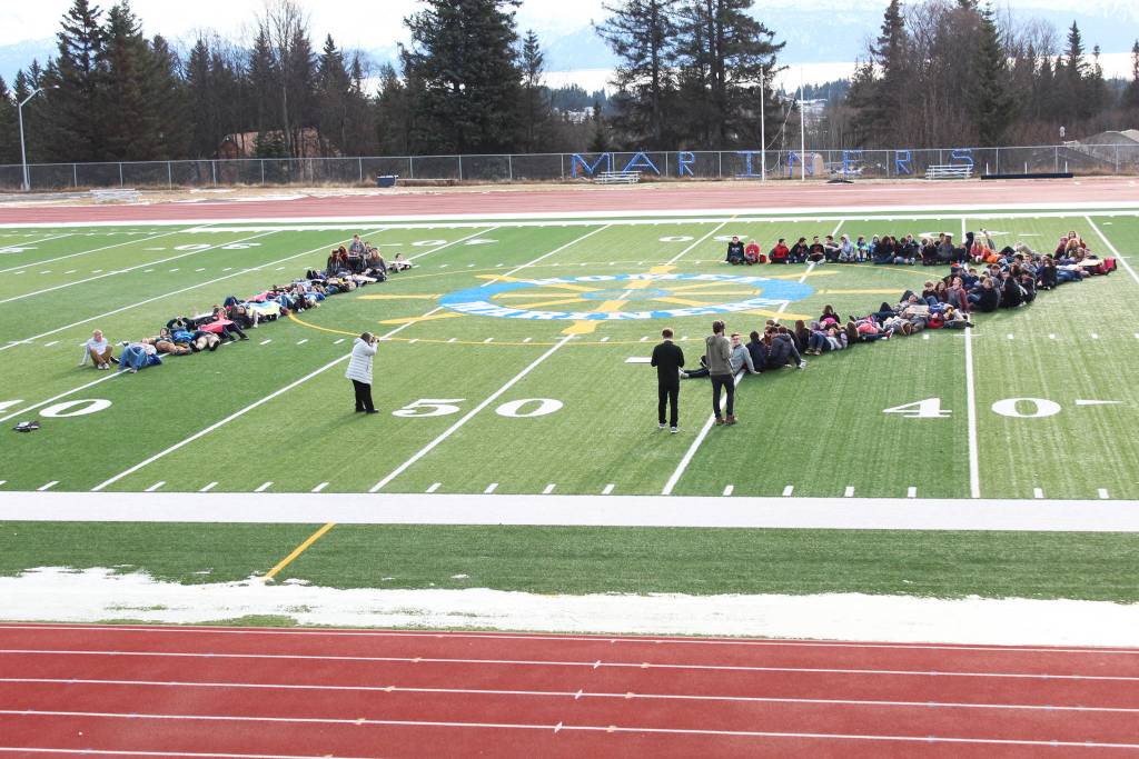About 100 Homer High School students lie down on the school&rsquo;s football field to form the number 17 on Wednesday, Feb. 21, 2018, to honor the students who were killed in the Feb. 14 mass shooting in Parkland, Florida. The Homer students staged a walkout at noon to advocate for safer schools. (Photo by Megan Pacer/Homer News)