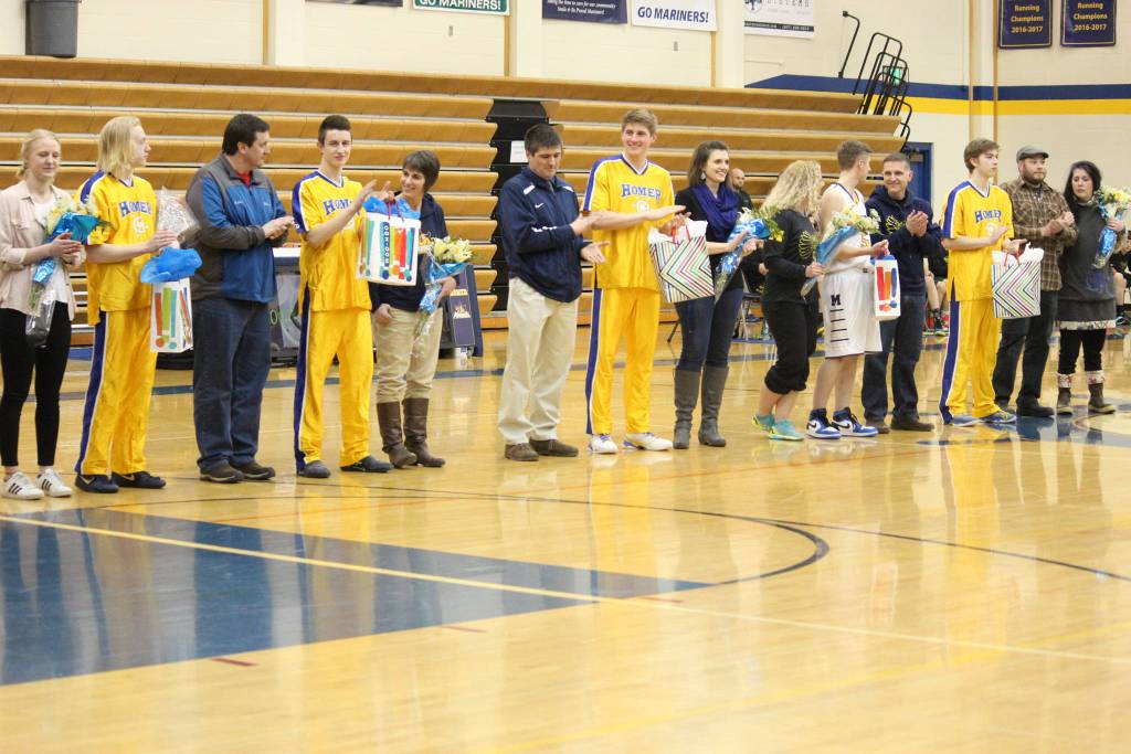 Homer&rsquo;s five male senior basketball players stand with members of their family during a Senior Night celebration before their game against Seward High School on Friday, March 2, 2018 in Homer, Alaska. (Photo by Megan Pacer/Homer News)