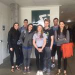 From left to right: Kira Milne, Jake Nelson, Ella Blanton-Yourkowski, Adeline Berry, Clayton Arndt, Coach Thad Gunther and Madison Story stand in front of the aquatic complex Beaverton, Oregon on Sunday, March 4, 2018. (Photo by Britt Milne)