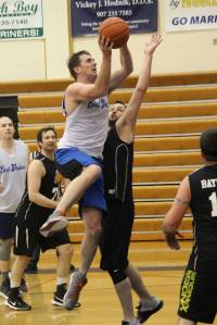 Dan Moitke (left) drives on Colby Kincaid during the Homer city basketball league&rsquo;s championship game Monday, March 5, 2018 at Homer High School. (Photo by Megan Pacer/Homer News)