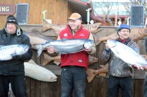 Ron Johnson, center, holds his winning king salmon of 25.65 pounds, at the 24th annual Homer Winter King Tournament on Saturday, March 23, 2017. Finishing in second, right, is Gino Del Frate of Palmer, with a 25.10 king, and in third is Gary Deiman, left, with a 24.30 king. (Photo by Michael Armstrong, Homer News)