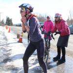 Annie Ridgely transitions from the cycling leg to the skiing leg of the Sea to Ski Triathlon on Sunday, March 25, 2018 at the Roger&rsquo;s Loop Trailhead off Highland Drive in Homer, Alaska. The race starts down at Mariner Park on the Homer Spit and ends with a ski after a bike climb up West Hill Road. (Photo by Megan Pacer/Homer News)