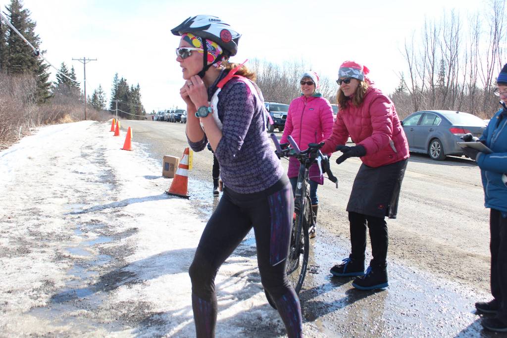 Annie Ridgely transitions from the cycling leg to the skiing leg of the Sea to Ski Triathlon on Sunday, March 25, 2018 at the Roger&rsquo;s Loop Trailhead off Highland Drive in Homer, Alaska. The race starts down at Mariner Park on the Homer Spit and ends with a ski after a bike climb up West Hill Road. (Photo by Megan Pacer/Homer News)