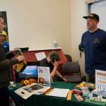 Homer High School student Ellie Syth, left, visits with wildland firefighter Aaron Seaton at the Alaska Division of Forestry table during the Kachemak Bay Campus College and Career Fair last Friday, March 30, 2018 in Homer, Alaska. About 400 students from 11 area schools as well as community members visited the annual event, said Kim Frost, KBC student and enrollment services coordinator. (Photo by Michael Armstrong/Homer News)