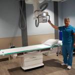 Image technologist Jay I&rsquo;nama poses by the new X-ray machine at an open house for the expanded and remodeled clinic last Friday, March 30, 2018 on Bartlett Street in Homer, Alaska. (Photo by Michael Armstrong, Homer News)