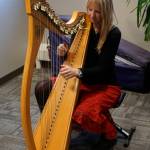 Michelle Morton plays the harp at an open house for the expanded and remodeled clinic last Friday, March 30, 2018 on Bartlett Street in Homer, Alaska. (Photo by Michael Armstrong, Homer News)