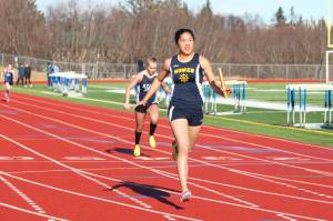 Photo by Megan Pacer/Homer News Homer&rsquo;s Kailee Veldstra crosses the finish line of the girls&rsquo; 400-meter relay to claim first place for her team Friday, April 13 at Homer High School.