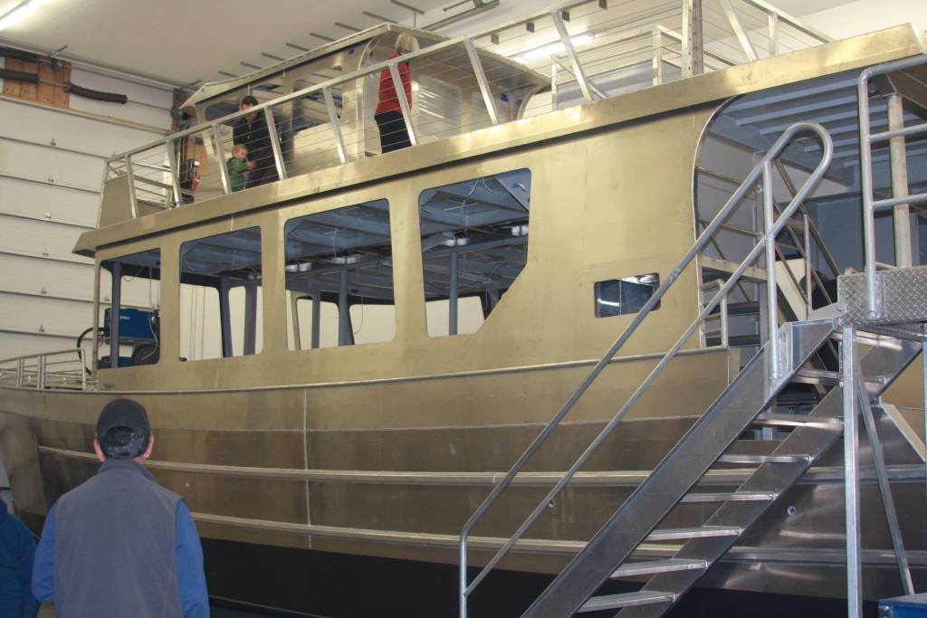 Homer locals attending Bay Weld&rsquo;s 200th boat celebration on Saturday, April 21 check out the numerous boats Bay Weld has built that are stored within their shop on East End Road in Homer, Alaska. (Photo by Delcenia Cosman)