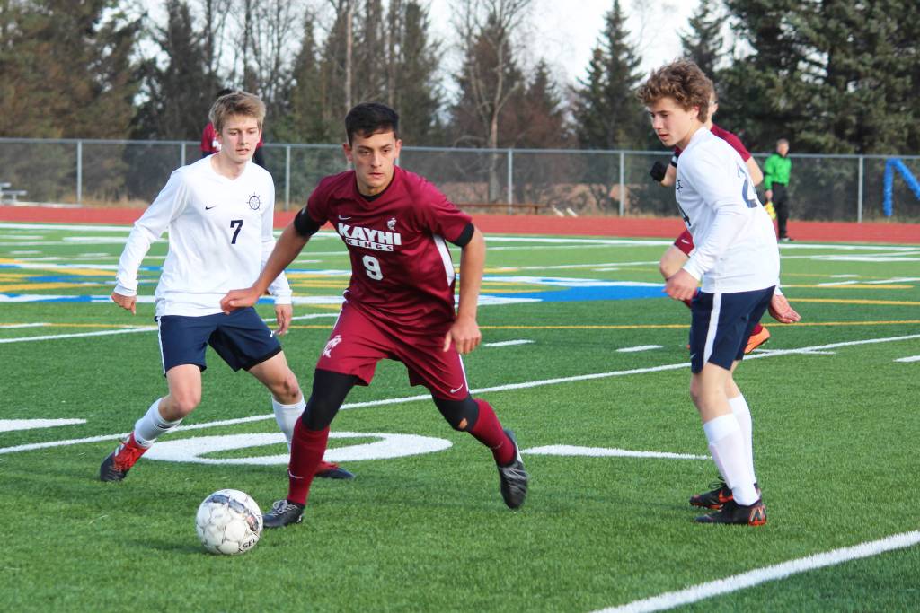 Ketchikan&rsquo;s Dawson Daniels looks for a place to take the ball while Homer&rsquo;s Simon Dye, left, and Austin Shafford, right, close in during their game Friday, May 4, 2018 at Homer High School in Homer, Alaska. Ketchikan won the match 1-0. (Photo by Megan Pacer/Homer News)
