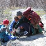 Wilderness Explorers Ruby Gervais and Jaelynn Kennon and the program coordinator, Damara Burnett, identify a patch of spring growth along Diamond Creek Trail on Wednesday, May 2. Samples of edible plants were collected and prepared for a snack later in the day. (Photo by McKibben Jackinsky)