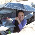 WIldernessX05: Using driftwood and an umbrella, Wilderness Explorer Ester Cabana demonstrates a simple solution to one of the seven steps of survival: shelter. (Photo by McKibben Jackinsky)