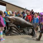 Children gather around Wildheart, the Giving Salmon, sculpture last Saturday at the ribbon cutting for the Homer Boat House. Christina Demetro of Anchorage created the sculpture with assistance from Homer community members, including children. (Photo by Kathyrn Henry)