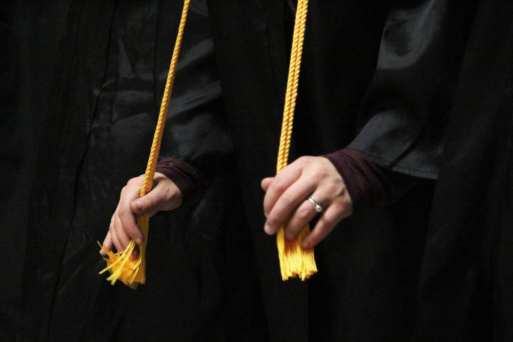 A Kachemak Bay Campus graduate fidgets with her tassels while waiting for her commencement ceremony to start Wednesday, May 9, 2018 at Homer High School in Homer, Alaska. KBC graduated students who earned their GED, associate degrees and more. (Photo by Megan Pacer/Homer News)