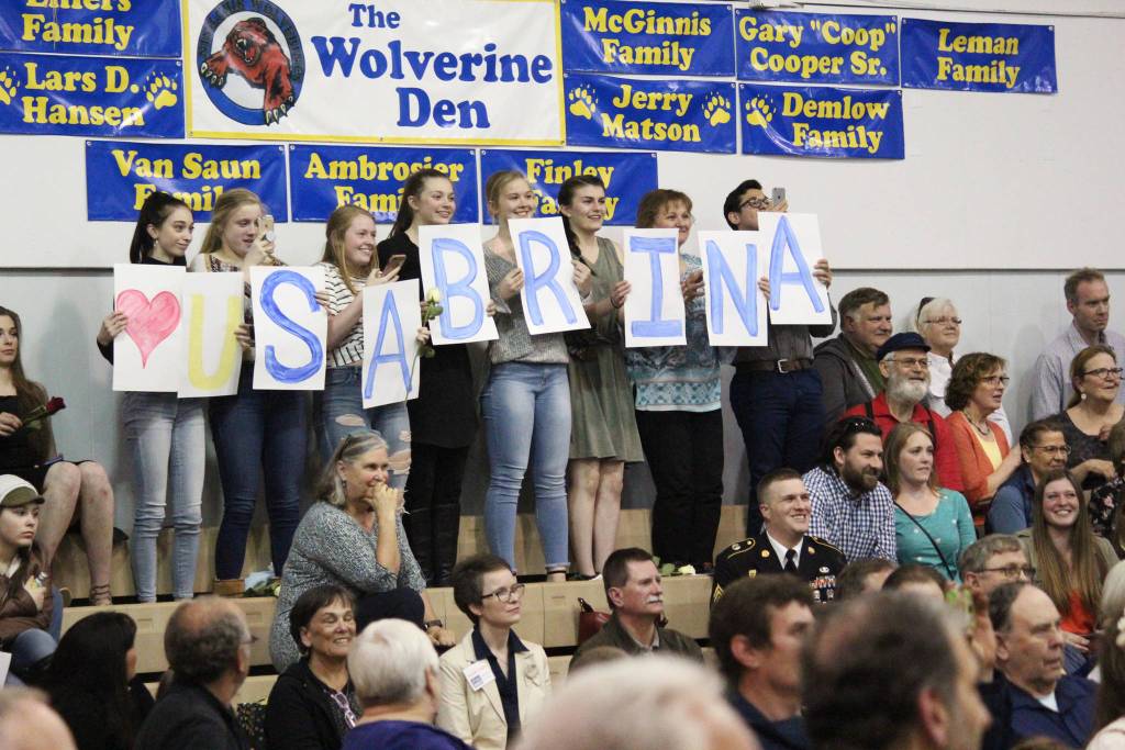 Ninilchik School students hold up signs spelling out &ldquo;(Heart) U Sabrina&rdquo; while 2018 graduate Sabrina Ferguson walks across the stage to claim her diploma Monday, May 21, 2018 during a ceremony at the school in Ninilchik, Alaska. (Photo by Megan Pacer/Homer News)