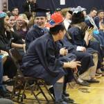 Members of the Ninilchik School graduating class of 2018 laugh and react as one of the speakers at their Monday, May 21, 2018 ceremony walks back to his seat at the school in Ninilchik, Alaska. The speaker accidentally took a page of salutatorian Chelsea Oberle-Lozano&rsquo;s speech from the podium after finishing his own. (Photo by Megan Pacer/Homer News)