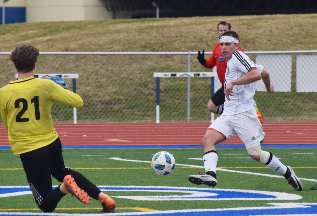 Kenai&rsquo;s Zack Tuttle takes a shot against Homer goalkeeper Tucker Weston (21) to score the game&rsquo;s first goal Saturday in the Peninsula Conference boys soccer championship at Soldotna High School. (Photo by Joey Klecka/Peninsula Clarion)