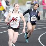 Kenai Central&rsquo;s Addison Gibson and Mikayla Leadens of Soldotna compete in the 800-meter relay Saturday, May 19, 2018, at Houston High School. (Photo by Jeremiah Bartz/Frontiersman.com)