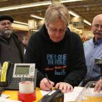 Laura Norton signs a document allowing her to take posession of a roughly $20,000 check, which she won through the Safeway Monopoly Game, during a presentation Tuesday, May 22, 2018 at Safeway in Homer, Alaska. (Photo by Megan Pacer/Homer News)