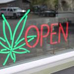 The open sign for Uncle Herb&rsquo;s, Homer&rsquo;s first marijuana retail store, lights up on opening day, Thursday, May 24, 2018 on Ocean Drive in Homer, Alaska. (Photo by Megan Pacer/Homer News)