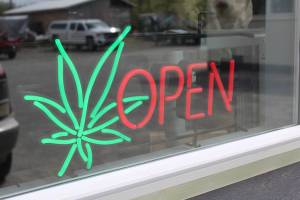 The open sign for Uncle Herb&rsquo;s, Homer&rsquo;s first marijuana retail store, lights up on opening day, Thursday, May 24, 2018 on Ocean Drive in Homer, Alaska. (Photo by Megan Pacer/Homer News)