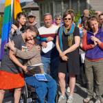 Catriona Reynolds, left, hugs Tess Dally, right, after Homer Mayor Bryan Zak read a Mayoral Recognition recognizing June as Homer Pride Month at about 6 p.m. Monday, June 11, 2018 outside Homer City Hall in Homer, Alaska. A crowd of about 75 people attended in support of Pride Month. Council members Shelly Erickson, Heath Smith and Thomas Stroozas notified the city clerk that they would not attend the June 11 meeting, forcing its cancellation because of lack of a quorum. Listening are council members Donna Aderhold, third from right, and Rachel Lord, second from right. (Photo by Michael Armstrong/Homer News)