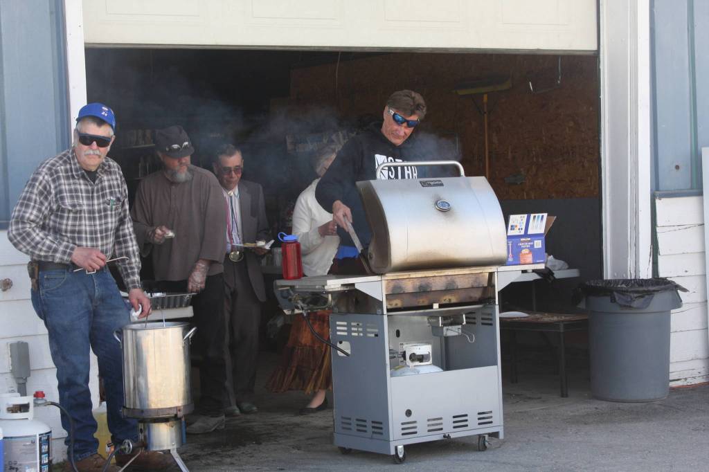Photo by Delcenia Cosman Pastor Roy Lovegrove from Great Land Worship Center helps prepare the free food provided by Thurmond&rsquo;s Far West Auto at their fourth annual Customer Appreciation Day on Saturday.